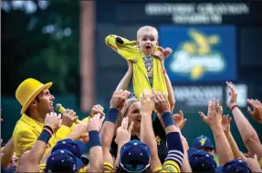  ?? ?? The Associated Press
Molly Knutson holds her baby, James, as the Savannah Bananas present the Banana Baby to the crowd while playing the Lion King song June 11 in Savannah, Ga.