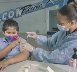  ?? Mel Melcon Los Angeles Times ?? ANGEL MACIAS receives a COVID vaccine from nurse Tracy Jones at San Fernando Middle School. Health experts say vaccines are safe and beneficial for kids.