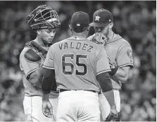  ?? Karen Warren / Staff photograph­er ?? Astros starter Framber Valdez confers with Martin Maldonado, left, and Carlos Correa during the third inning Friday night.