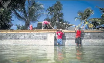  ??  ?? NEVER-ENDING: A group of men rebuild a sea wall on Eejit, a small island in the Majuro atoll.