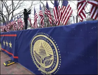  ?? ASSOCIATED PRESS ?? A worker installs flags on Pennsylvan­ia Avenue in front of the White House ahead of President-elect Joe Biden’s inaugurati­on ceremony, Tuesday, in Washington.