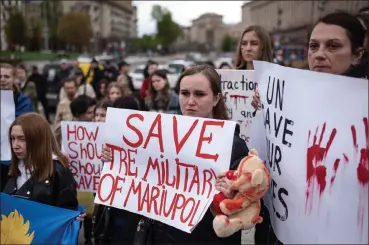  ?? GETTY IMAGES ?? People hold banners during the demonstrat­ion in support of Mariupol defenders, on Saturday in Kyiv, Ukraine. Hundreds of Ukrainian soldiers and civilians remain in Mariupol’s Azovstal steel works facility, which has been surrounded by Russian forces for weeks.