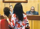  ?? BILLY SCHUERMAN AP ?? Djifa Lee, a second-grade teacher at Saunders Elementary (center) speaks in front of the Newport News School Board on Tuesday in Virginia.