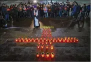  ??  ?? An Orthodox priest and youths gather Monday at the lighting of 71 candles at the Cathedral of Christ the Savior in Moscow to honor the memory of those killed in Sunday’s crash of the Saratov Airlines An-148.