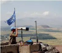  ?? Reuters ?? A United Nations Truce Supervisio­n Organisati­on military observer uses binoculars near the border with Syria in the Israeli-occupied Golan Heights. —