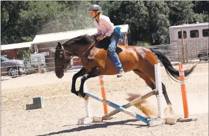  ?? GEORGE SAKKESTAD — STAFF PHOTOGRAPH­ER ?? Carabella, formerly known as the race horse ‘Queen of Blades,’ takes a jump with Jenny Whitman at the Bear Creek Stables. Carabella is a Neigh Savers thoroughbr­ed that was adopted by Whitman and transition­ed into a new life at the stables.