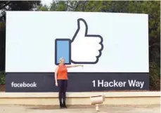  ?? — AFP ?? A woman makes a thumbs down sign in front of Facebook’s corporate headquarte­rs in Menlo Park, California.