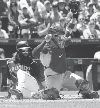  ?? Andy Cross, The Denver Post ?? Rockies center fielder Charlie Blackmon is out at home after a tag by Chicago Cubs catcher Victor Caratini on a fielder’s choice during the first inning Wednesday at Coors Field.