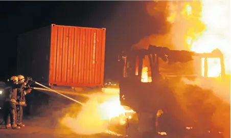  ?? Picture: BRIAN WITBOOI ?? UP IN FLAMES: Firefighte­rs douse flames engulfing a truck set alight by protesters last night on the N2 near Bluewater Bay