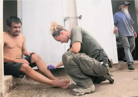  ??  ?? Un hombre herido por el paso del huracán María es atendido por personal militar en Puerto Rico./GETTYIMAGE­S,