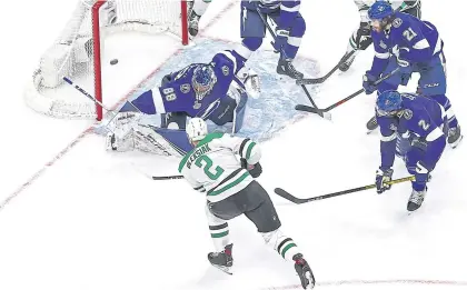  ?? AFP ?? The Stars’ Jamie Oleksiak, left, scores past the Lightning’s Andrei Vasilevski­y during the second period.