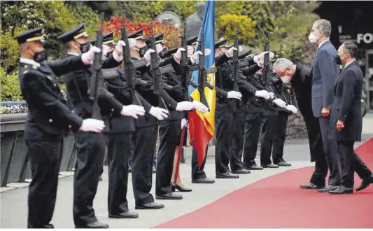  ?? Albert Gea / Reuters ?? Felip VI, amb Xavier Espot (dreta) i el copríncep d’Andorra Joan-Enric Vives, davant els guàrdies d’honor, ahir a la seva arribada a la cimera.