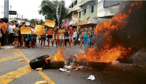  ?? Fotos Joel Silva/Folhapress ?? Manifestan­tes ateiam fogo a pneus e bloqueiam avenida em Vitória em frente a batalhão da Polícia Militar para pedir o retorno do policiamen­to nas ruas