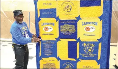  ?? The Sentinel-Record/Richard Rasmussen ?? BLUE AND GOLD: James Ford, Class of 1963, hangs a quilt made of reunion T-shirts up during the Langston Alumni Reunion picnic at Hot Springs World Class High School on Thursday.