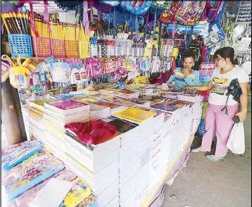  ?? BOY SANTOS ?? A woman looks over school supplies sold at the Commonweal­th Market in Quezon City yesterday.