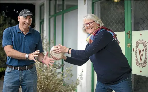  ?? VIRGINIA WOOLF/ STUFF ?? Cheese guru Juliet Harbutt, passes a monello cheese to Flavio Donati, co-owner of ViaVio Cheese in Nelson and a former profession­al rugby player from Italy.