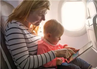  ?? TNS PHOTO ?? UNSAFE POLICY: Although airlines allow children younger than 2 to fly without a ticket, experts say the safest place for a child on an airplane is in a safety seat.