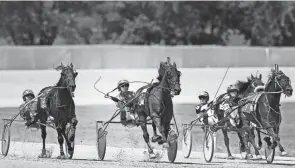  ?? JONATHAN QUILTER/COLUMBUS DISPATCH ?? In this file photo, Chris Page, center, drives Always Connected in 2015. Scioto Downs canceled harness racing this week, but races are expected to resume Friday.