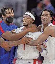  ?? Carlos Osorio Associated Press ?? CLIPPERS guard Reggie Jackson receives accolades from teammates after hitting the winning basket with 2.8 seconds left.