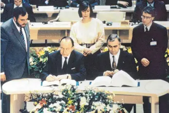  ?? FOTO: DPA ?? Die Geburtsstu­nde des Euro: Hans-Dietrich Genscher (FDP/sitzend, li.) und Theo Waigel am 7. Februar 1992.