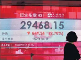  ?? Anthony Wallace AFP/Getty Images ?? A DISPLAY in Hong Kong shows how the Hang Seng index fared Tuesday. In the U.S., big industrial and tech stocks slid as smaller companies made modest gains.