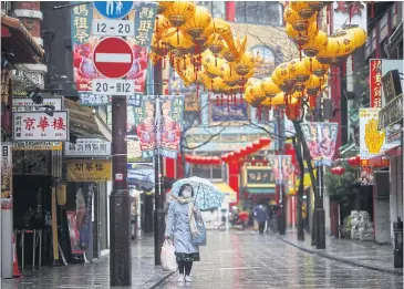  ?? REUTERS ?? A woman walks on an almost empty street in Yokohama’s Chinatown, south of Tokyo yesterday.