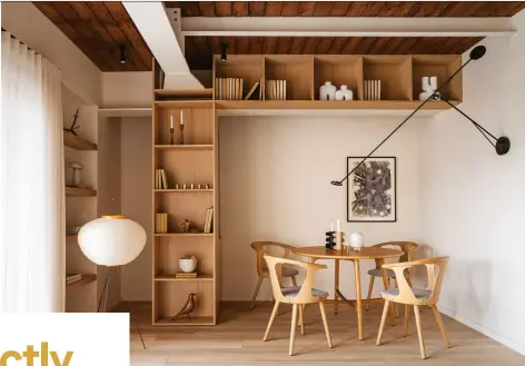  ?? ?? RIGHT: Complement­ing the custom millwork that designer Yana Molodykh installed at strategic locations throughout the apartment, two alcoves with recessed oak shelving flank either side of the balcony door. Vitra’s
Akari floor lamp by Isamu Noguchi is a perfect airy accent to the space.