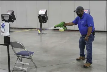  ?? The Sentinel-Record/Grace Brown ?? CARES ACT MONEY NEEDED: Hot Springs Convention Center employee Curtis Franklin disinfects a chair at the facility’s early voting site Wednesday. Visit Hot Springs CEO Steve Arrison said in addition to hosting events and trade industry meetings, the building also serves as a civic space.