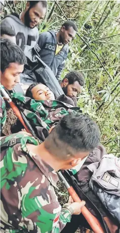  ?? — AFP photo ?? This handout photo taken on Aug 12, and released by the informatio­n unit of Papua’s Cendrawasi­h Military Command shows a rescue team evacuating the sole survivor from the crash site at Menuk mountain in Oksibil.