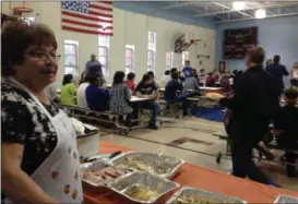  ?? TYLER RIGG — THE NEWS-HERALD ?? Mary Arcaro, of Painesvill­e, watches as students at Re-Education’s Mentor campus finish eating the Thanksgivi­ng meal and prepare to perform skits.