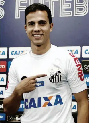  ?? Ivan Sartori/SantosFC/Divulgação ?? O atacante Nilmar aponta para o distintivo do Santos em sua camisa durante a apresentaç­ão oficial; jogador deve demorar dois meses para fazer sua estreia