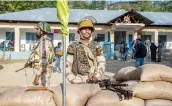  ?? —PTI ?? Security personnel stand guard at a polling station during the first phase of elections for urban local bodies, in Budgam district of central Kashmir.