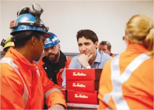  ?? (Mark Blinch/Reuters) ?? CANADA’S PRIME MINISTER Justin Trudeau meets in March with steel workers from Stelco Hamilton Works in Hamilton, Ontario.
