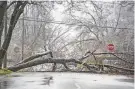  ?? RODNEY COLEMAN-ROBINSON/ KALAMAZOO GAZETTE VIA AP ?? A fallen tree blocks a street Thursday in Kalamazoo, Mich. An ice storm in Michigan coated branches, power lines and utility poles with ice and led to widespread power outages.