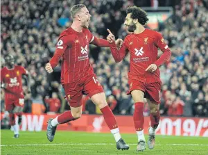  ??  ?? Liverpool’s Mohamed Salah, right, celebrates with Jordan Henderson after scoring against Tottenham at Anfield.