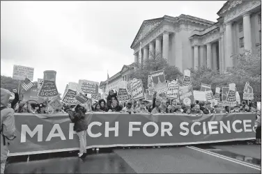  ?? AP/SAIT SERKAN GURBUZ ?? A March for Science crowd passes the Environmen­tal Protection Agency offices Saturday in Washington in one of many Earth Day events around the world in support of science, scientists and scientific facts.