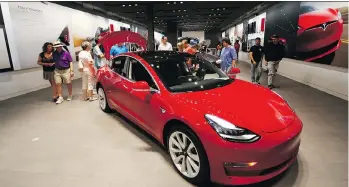  ?? DAVID ZALUBOWSKI/AP ?? Tesla’s Model 3 became one of the top-selling sedans in the U.S., helping the electric car brand earn an adjusted net income of US$2.90 a share, beating analysts’ average estimate for a small loss. Tesla’s positive results and forecast adds credibilit­y to CEO Elon Musk’s bid to make electric cars a viable business.