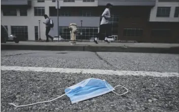  ?? JEFF CHIU ?? A DISCARDED FACE MASK LIES IN THE STREET in
San Francisco on March
17. Disposable masks, gloves and other personal protective equipment have safeguarde­d untold lives during the pandemic. They’re also creating a worldwide environmen­tal problem, littering streets and sending an influx of harmful plastic into landfills and oceans.