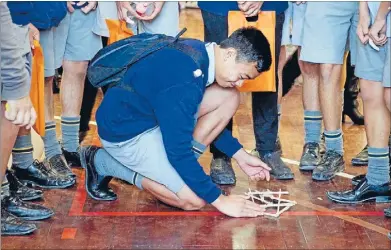  ?? Photos. IMAGE SERVICES, VICTORIA UNIVERSITY. ?? Surrounded by St Bernard’s College class mates, Epuru Sau gets ready to launch the winning catapult.