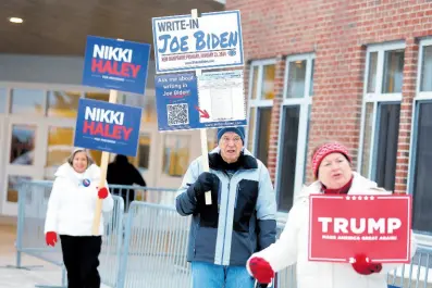  ?? AP ?? Candidate supporters stand outside a polling location in the presidenti­al primary election, on January 23, in Windham, New Hampshire.