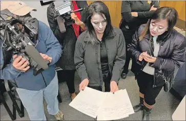  ?? Jeffery Collins Associated Press ?? SHERIFF'S CAPT. Maria Yturria shows notes on the 1978 slaying of Evelyn Weston to the media in Columbia, S.C. Weston’s death is linked to convicted murderer Sam Little, who has claimed to have killed 90 women.