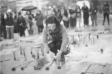  ??  ?? A demonstrat­or lights a candle in a protest demanding justice for the fire victims at the Virgen de Asuncion children shelter in Guatemala, outside Bellas Artes museum, in Mexico City. — Reuters photo