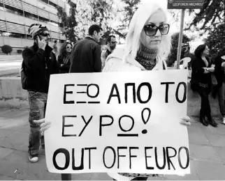  ??  ?? UNA MUJER sostiene un cartel en Nicosia, capital de Chipre, en demanda de una solución a la crisis económica que vive ese país.