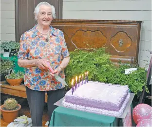  ??  ?? Margaret Monk, who has attended the Poowong East Flower Show since she was a child, cuts the 80th birthday cake.