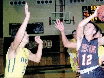  ?? PHOTO BY RICK PECK ?? McDonald County’s Max Dill goes in for a layup as St. Joseph Lafayette’s Caleb Bennett (2) looks on during the Irish’s 58-53 win Monday in the opening round of the Neosho Holiday Classic.