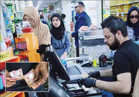  ??  ?? In this file photo, a casher holds Iraqi banknotes at a mall in Baghdad, Iraq. (Inset): A bike mechanic counts money on his shop, in the southern suburb of Beirut, Lebanon. The coronaviru­s
pandemic has reawakened debate about the continued viability of what has been the physical lifeblood of global economies: paper money and coins. (AP)