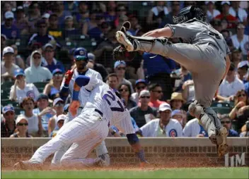  ??  ?? San Diego Padres catcher Austin Hedges (right) jumps after tagging out Chicago Cubs’ Addison Russell (left) at home during the fourth inning of a baseball game in Chicago, on Saturday. AP Photo/NAm Y. huh