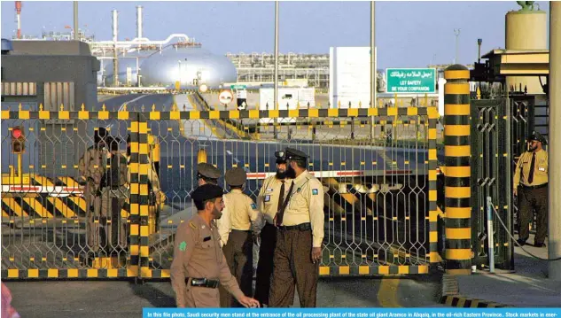  ??  ?? In this file photo, Saudi security men stand at the entrance of the oil processing plant of the state oil giant Aramco in Abqaiq, in the oil-rich Eastern Province.. Stock markets in energy-rich Gulf states tumbled with Saudi shares down 3.0 percent following worldwide losses amid fears over the coronaviru­s pandemic and an oil price war. — AFP
