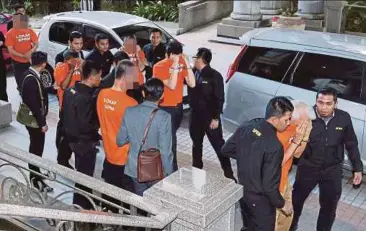  ?? PIC BY AHMAD IRHAM MOHD NOOR ?? MACC officers escorting the six individual­s at the magistrate’s court in Putrajaya yesterday.