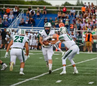  ?? AIMEE BIELOZER — FOR THE MORNING JOURNAL ?? Elyria Catholic QB Brady Cook hands the ball off to Levi Ellis against Midview on Sept. 3.